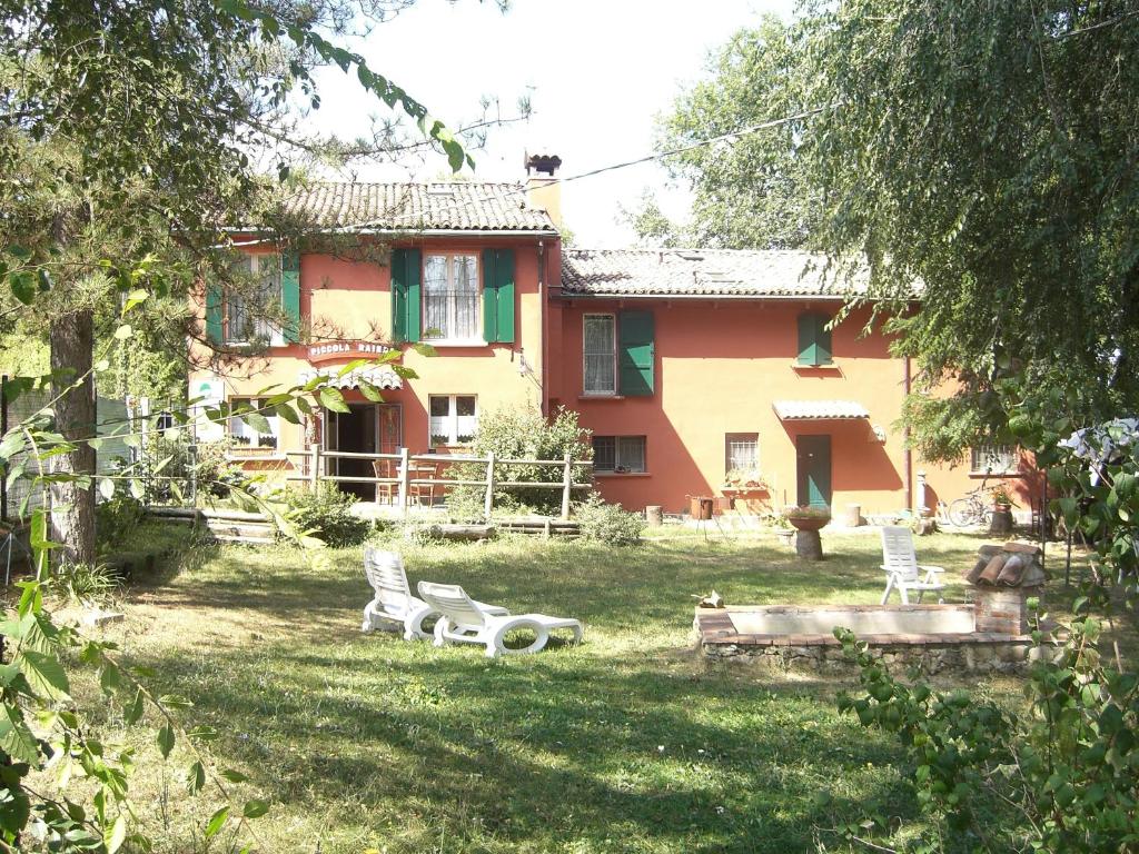 una casa con un patio con sillas delante en Agriturismo Piccola Raieda en Sasso Marconi