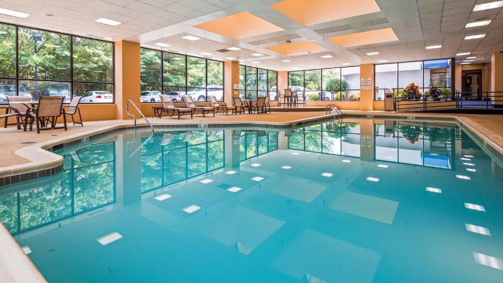 a swimming pool in a hotel with blue water at Best Western Plus BWI Airport Hotel - Arundel Mills in Elkridge