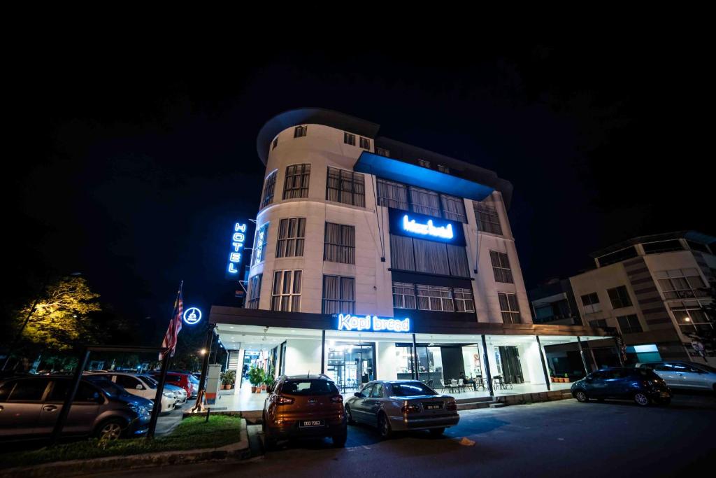 a building with cars parked in a parking lot at night at bizz hotel in Puchong