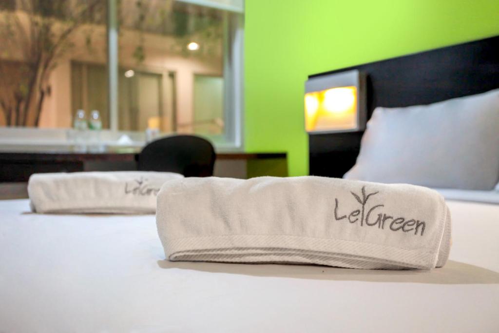 Postel nebo postele na pokoji v ubytování LeGreen Suite Tondano