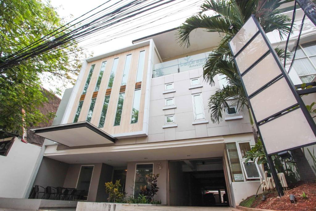 un bâtiment avec un palmier en face dans l'établissement LeGreen Suite Kuningan, à Jakarta