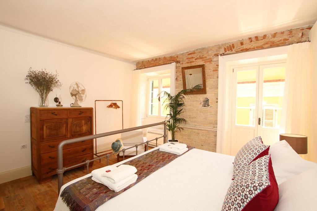 een slaapkamer met een bed met twee handdoeken erop bij 1861 Liston Boutique flat in Corfu-stad