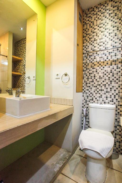 un bagno con un water bianco e un lavandino di LeGreen Suite Poso a Giacarta