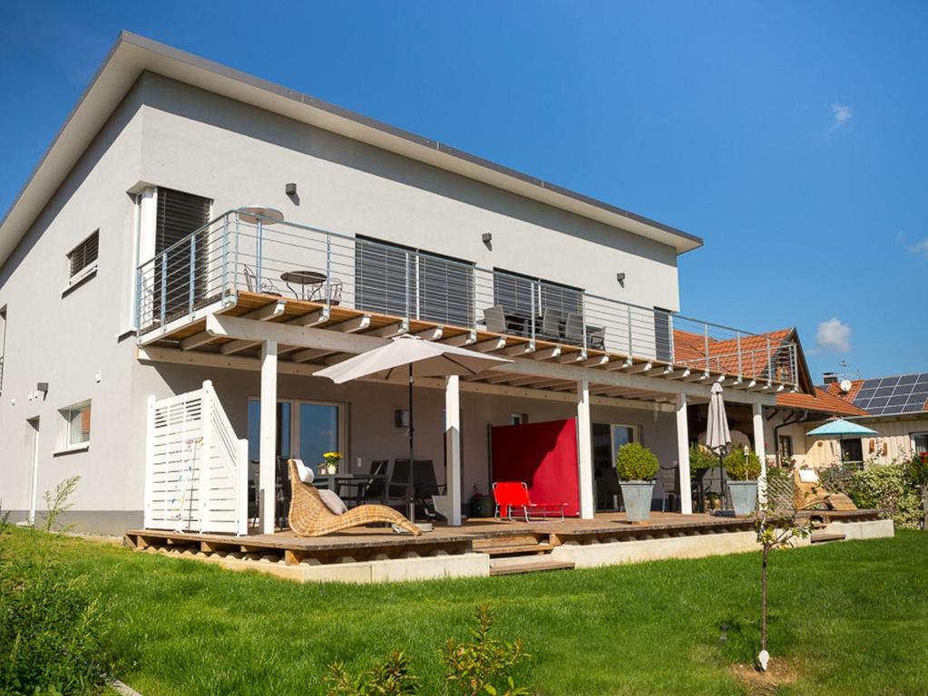 een groot wit huis met een terras en patio bij Ferienwohnungen beim Wohlfühlhaus Freiamt in Freiamt