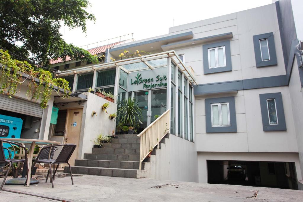 un edificio con una mesa y sillas delante de él en LeGreen Suite Penjernihan, en Yakarta
