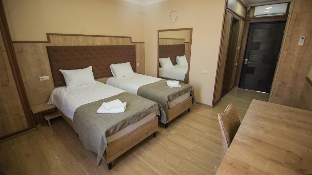 een hotelkamer met 2 bedden en een tafel bij Hotel Juralius in Tbilisi City