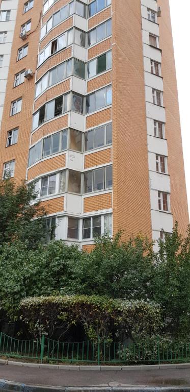 モスクワにあるАпартаменты Островитянова 5の木々が目の前に立つ高いレンガ造り