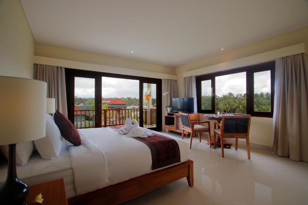 Postel nebo postele na pokoji v ubytování DLobong Suites Ubud