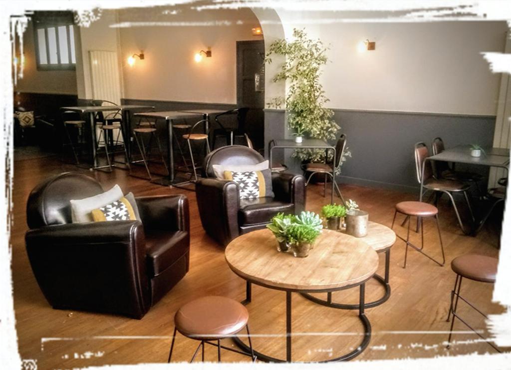 a living room with leather furniture and a table at L'Instant Sévigné in Grignan