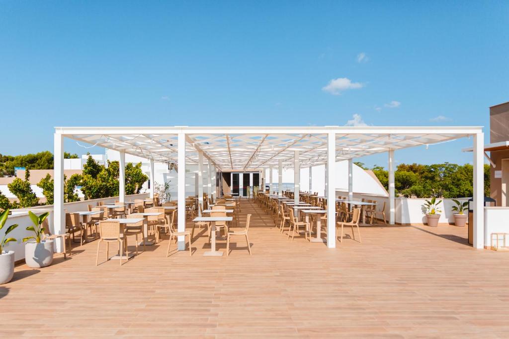 a pavilion with tables and chairs on a boardwalk at Torre Cintola Greenblu Sea Emotions in Monopoli