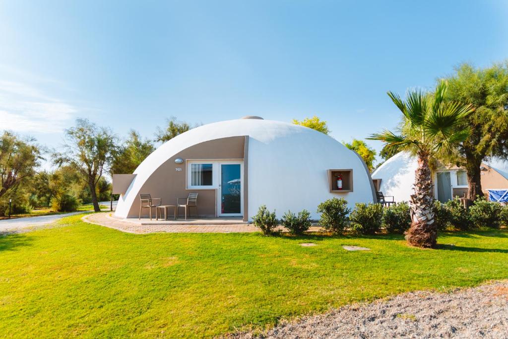 a dome house with a lawn in front of it at Torre Cintola Greenblu Sea Emotions in Monopoli