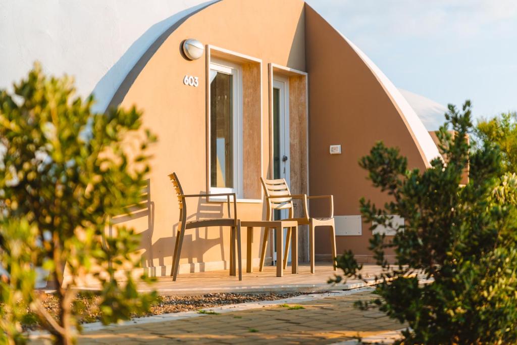 a house with two chairs and a table on a porch at Torre Cintola Greenblu Sea Emotions in Monopoli