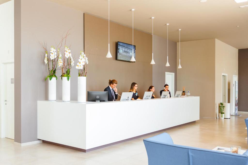 a group of people sitting at a reception desk at Torre Cintola Greenblu Sea Emotions in Monopoli