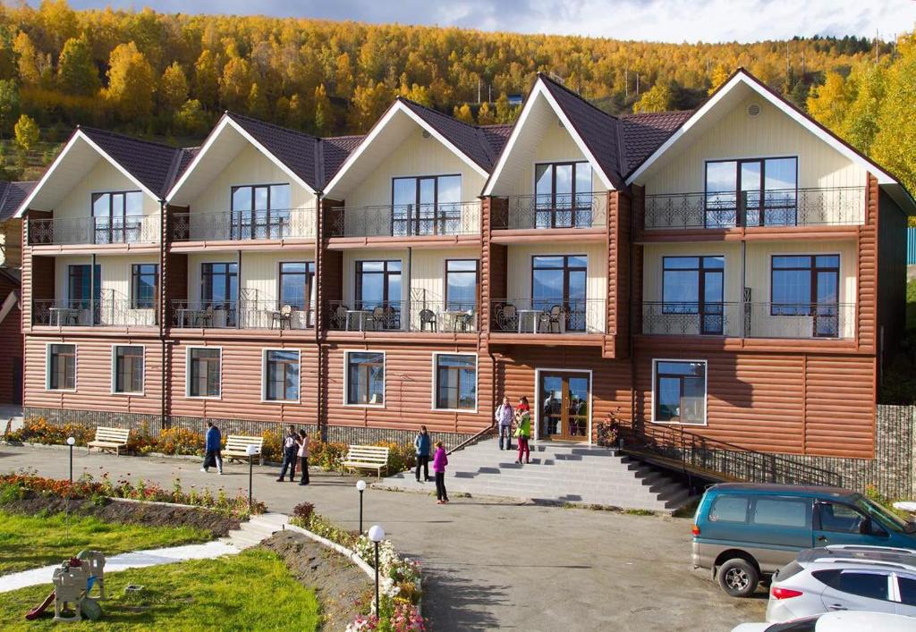 a large building with people standing outside of it at Hotel complex Baikalskiy Rai in Kultuk