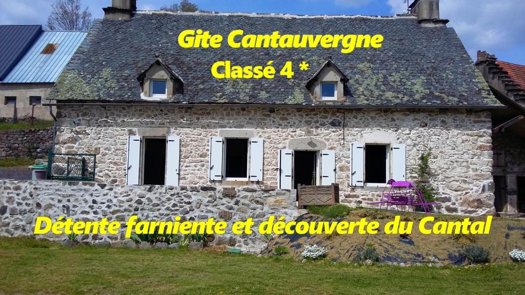 a stone building with a sign on the side of it at Gite CANTAUVERGNE in Vebret