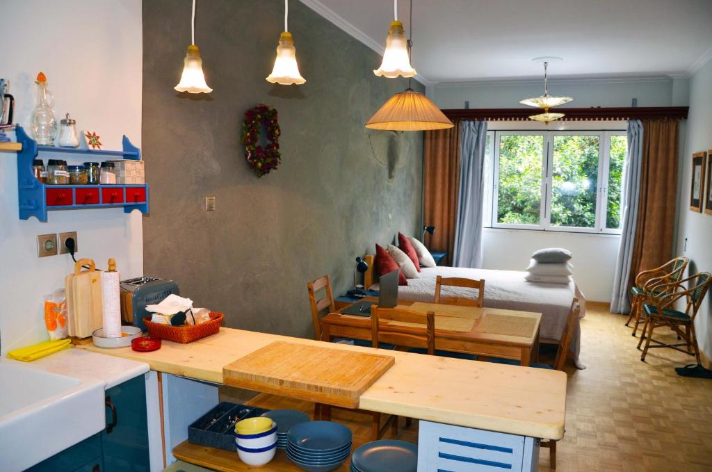 una cucina e un soggiorno con letto e tavolo di Mia's cozy flat in Ermou, 3 min from "Monastiraki" ad Atene