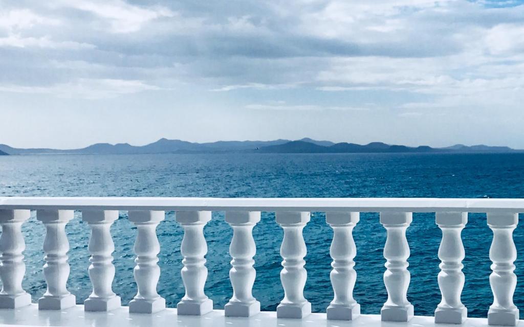 a white railing with the ocean in the background at La Paloma Blanca in Playa Blanca