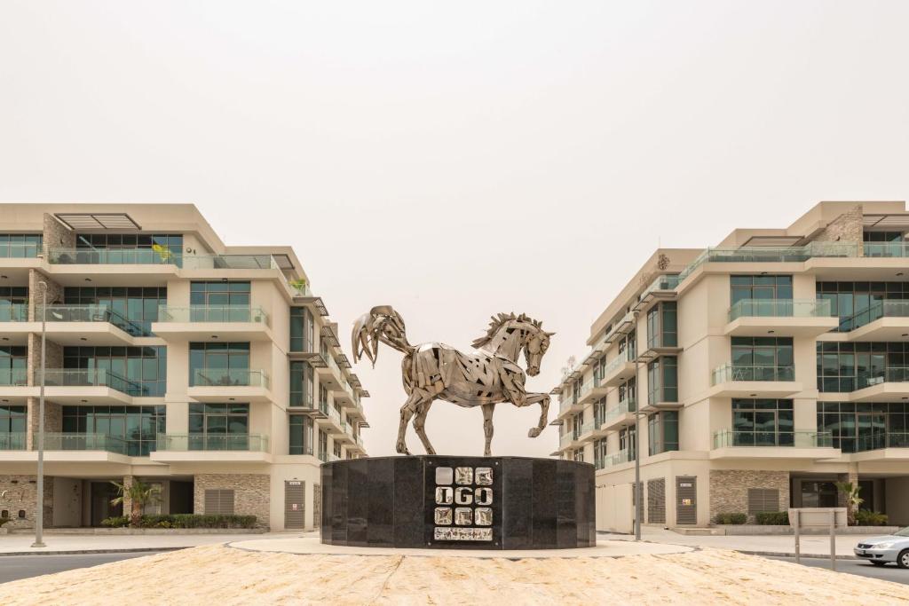 a statue of a horse in front of a building at Blue Ocean Holiday Homes - Polo Residence C1 in Dubai