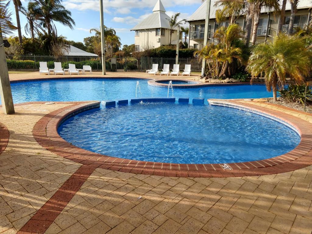 a swimming pool with a pool table and chairs at Private Apartments at The Sanctuary Resort in Bunbury
