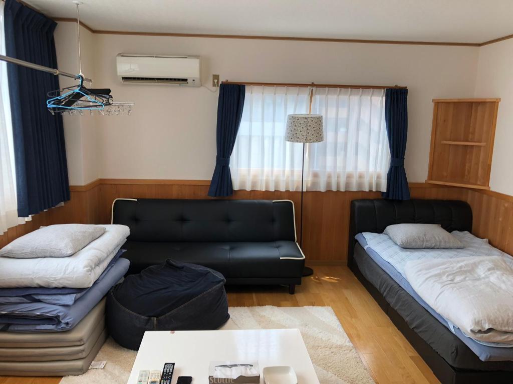 Kurashiki Base Inarimachi في كوراشيكي: غرفة معيشة مع أريكة وسرير