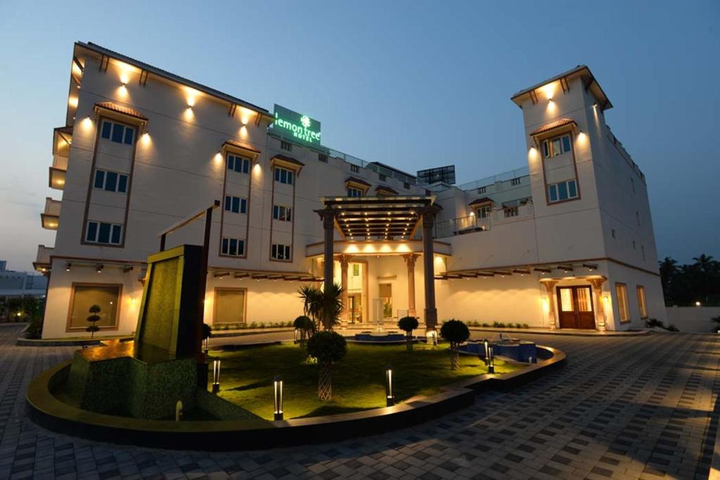 a large white building with lights on it at Lemon Tree Hotel Coimbatore in Coimbatore