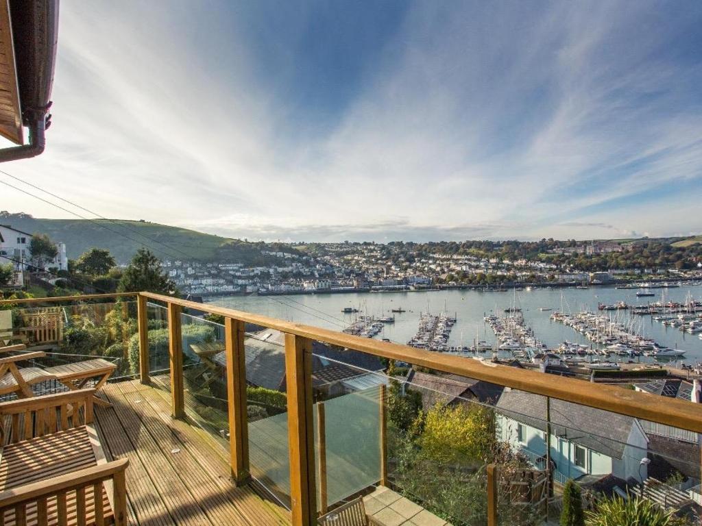 a balcony with a view of a harbor with boats at Totherside in Dartmouth