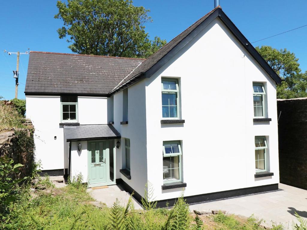 a white house with a black roof at Ty Ffarm at Gellilwch in Pontypridd