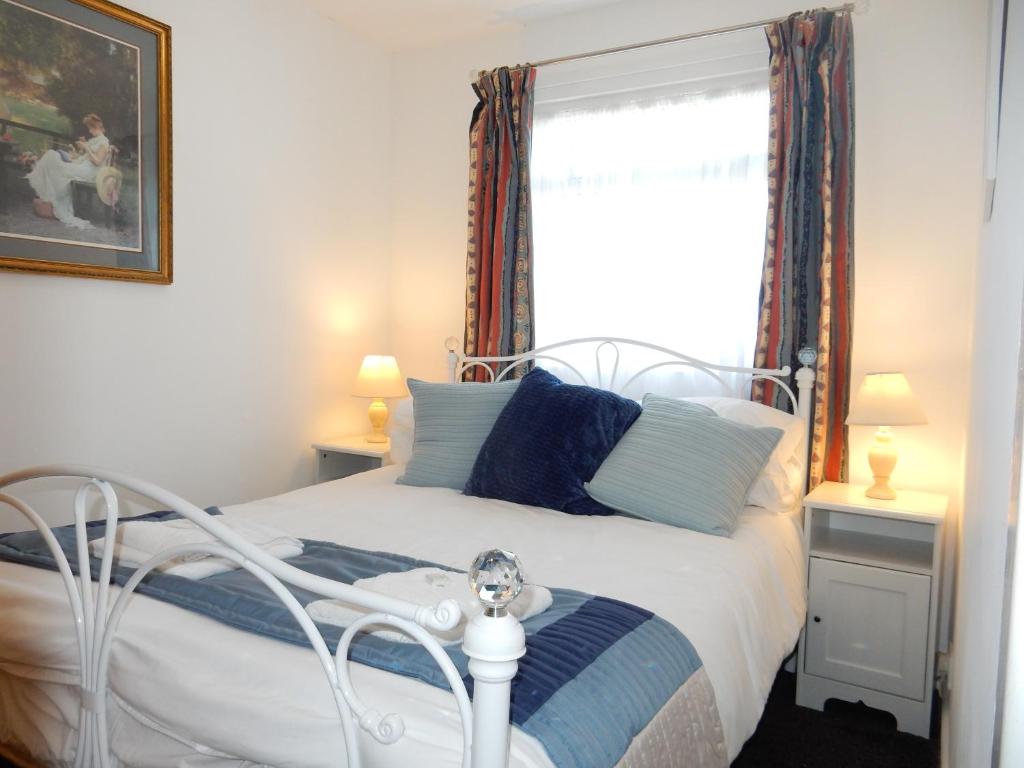 a bedroom with a white bed and a window at Dartmouth Chalet Holidays in Dartmouth