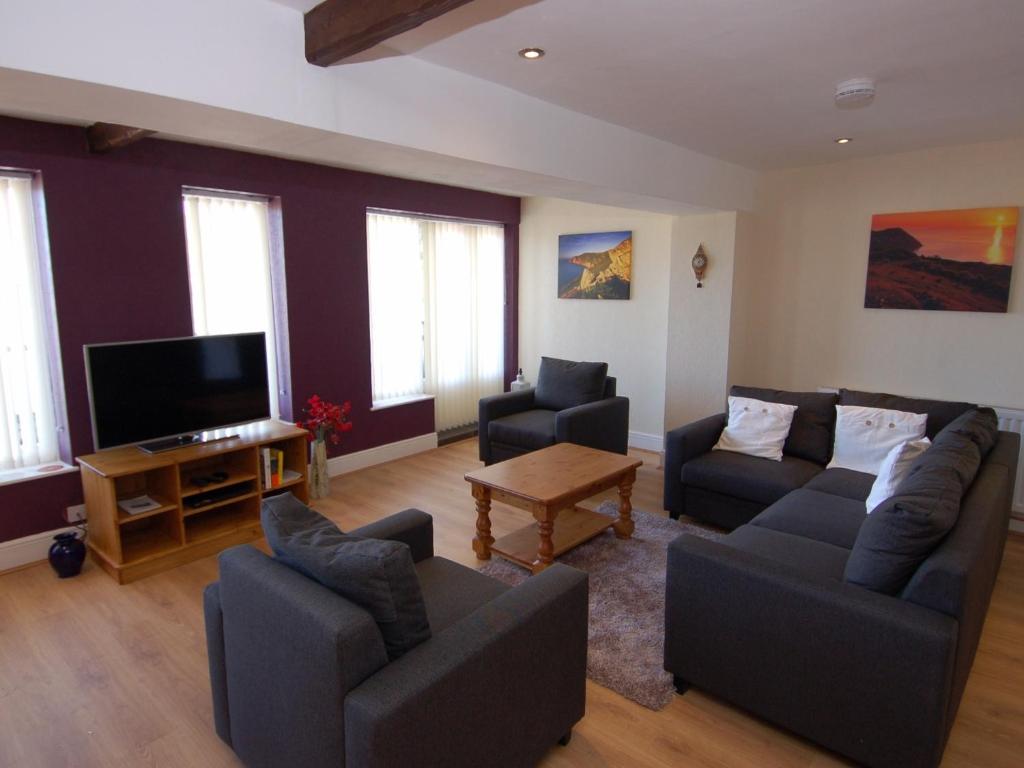 a living room with two couches and a flat screen tv at Old Lyn Cottage in Lynmouth