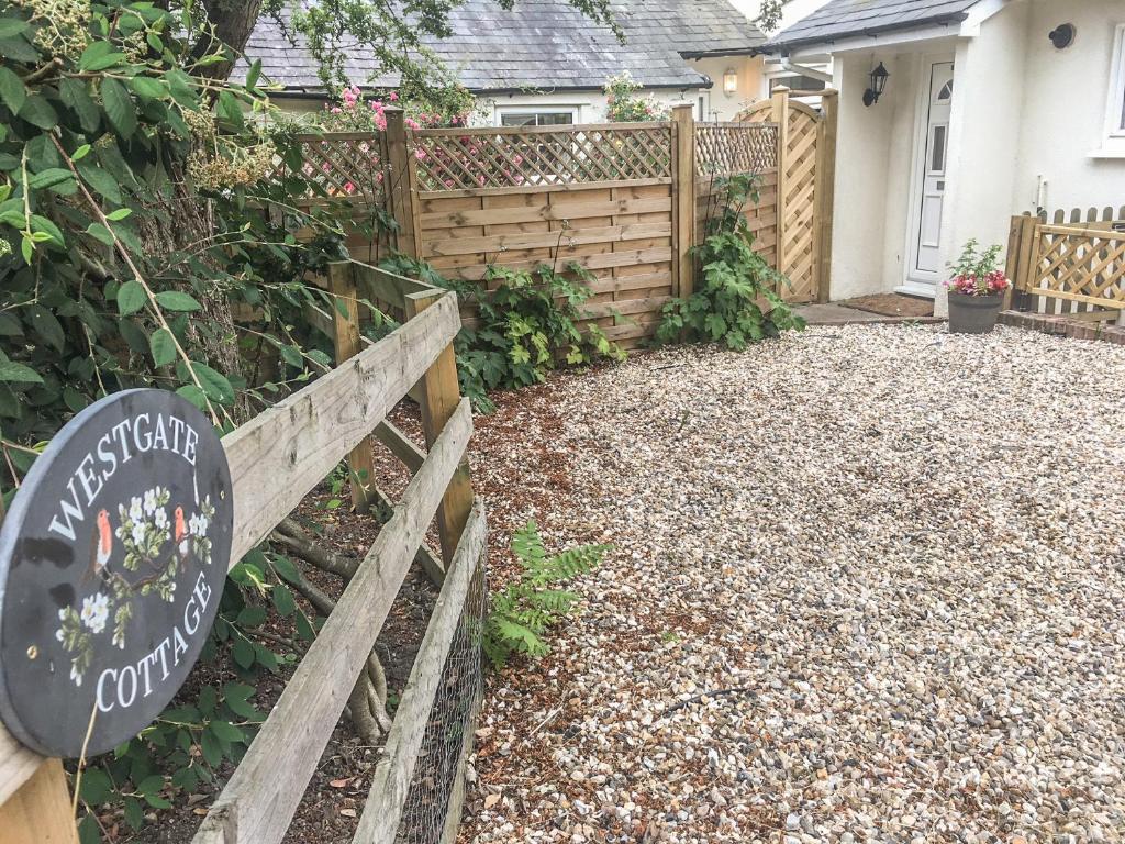 um sinal de jardim em frente a uma cerca em Westgate Cottage em Sittingbourne