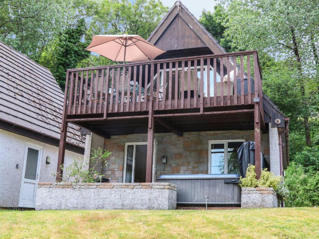 a house with a large deck with an umbrella at Valley Lodge 48 in Callington
