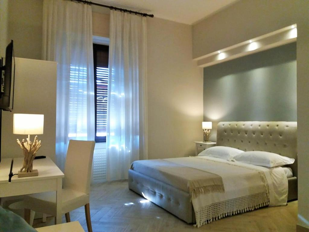 una camera con letto, tavolo e scrivania di B&B Oriental Palace a Catania