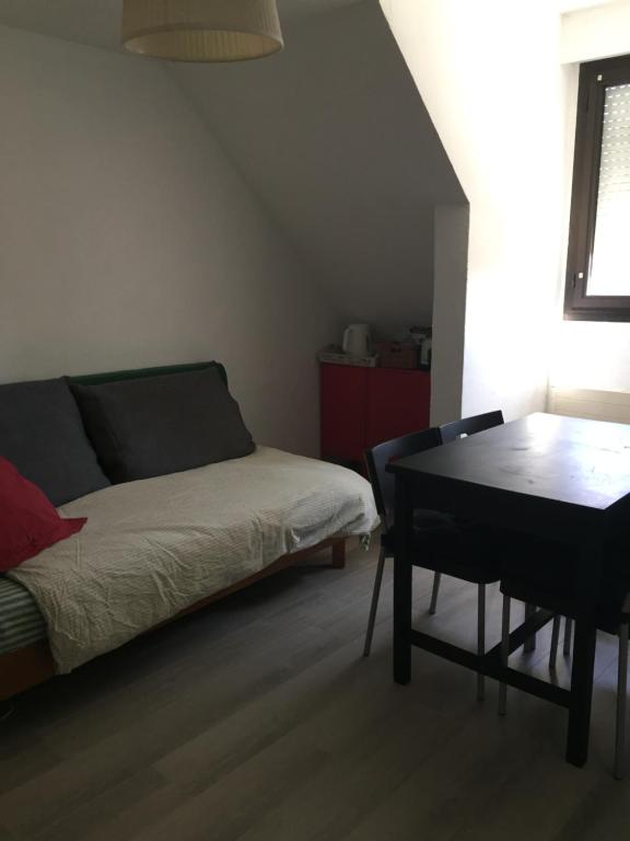 - une chambre avec un lit, une table et un bureau dans l'établissement Cheng, à Saint-Germain-en-Laye