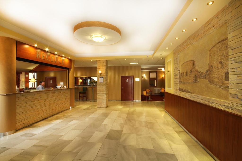 a lobby of a restaurant with a painting on the wall at Hotel Strážnice in Strážnice