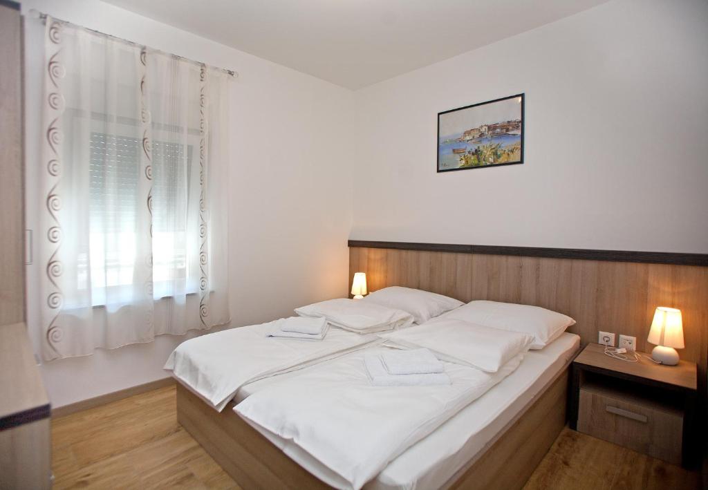 Posteľ alebo postele v izbe v ubytovaní Apartments Maslina II