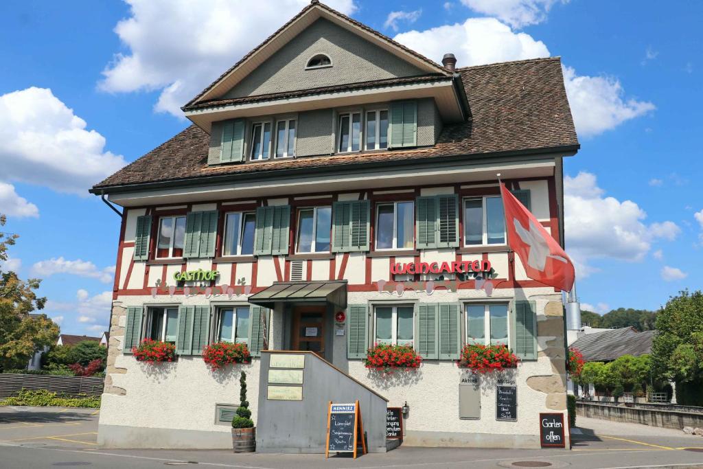 a building with a flag in front of it at Gasthof Pizzeria Weingarten in Affoltern