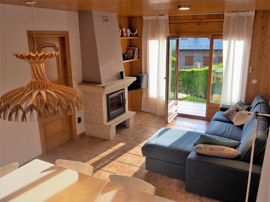 a living room with a blue couch and a fireplace at Apartament Carpe Diem en LLívia in Llivia