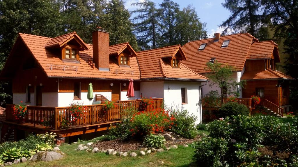 uma casa com um telhado de madeira e um quintal em Dom Natury em Karpacz