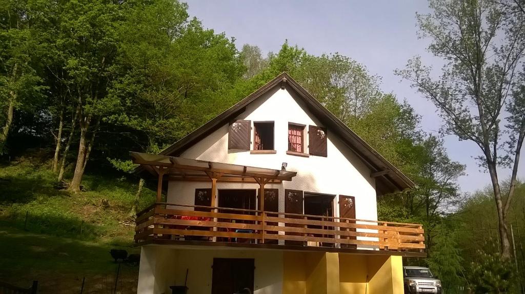una casa con techo de gambrel y porche en Gîte de la baerenbach, en Hazelbourg