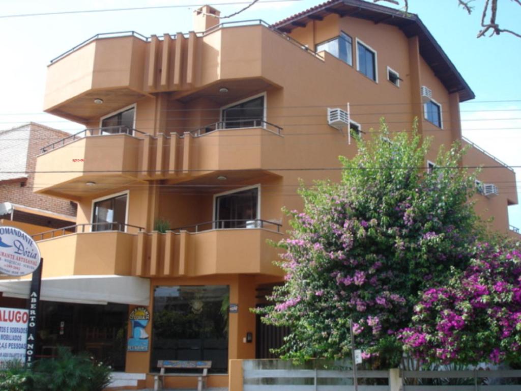 un edificio marrón con un árbol delante de él en Residencial Com. Dória, en Bombinhas