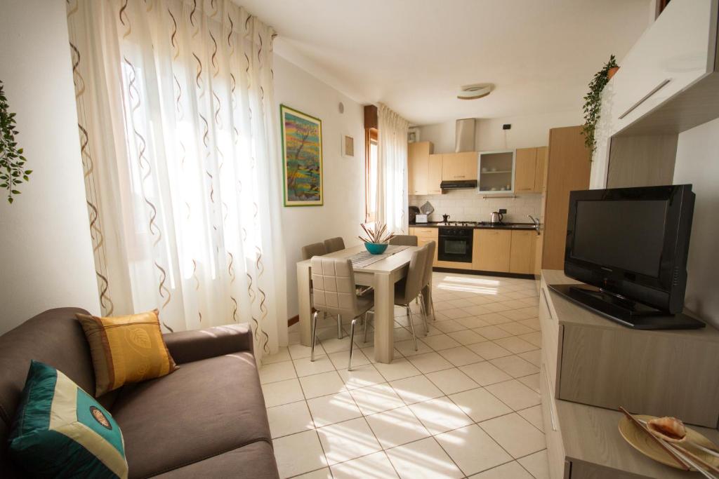 salon z kanapą i stołem oraz kuchnia w obiekcie appartamento a cavallino w Cavallino-Treporti