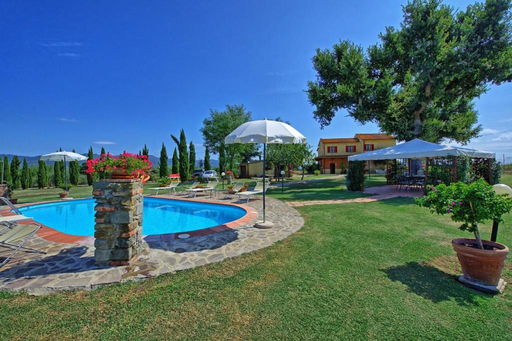 - une piscine dans une cour avec des parasols dans l'établissement Agriturismo Podere Delle Querci, à Castiglion Fiorentino