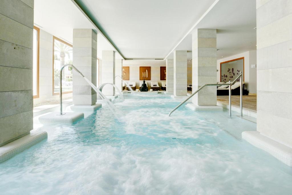 a swimming pool with blue water in a house at Grupotel Los Príncipes & Spa in Playa de Muro