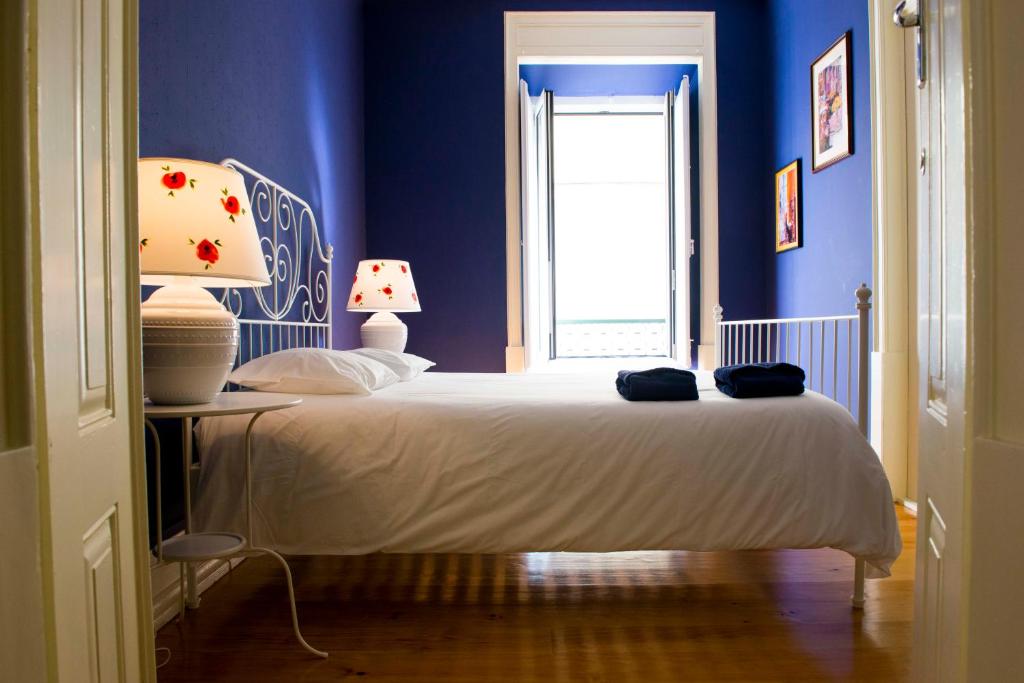 a bedroom with a bed with a blue wall at La Palma Hostel Leiria in Leiria