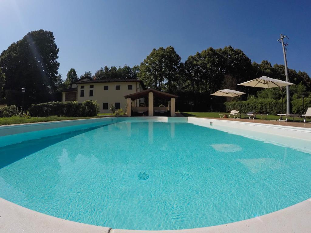 una gran piscina de agua azul frente a una casa en CASALE LA FATA -tipico toscano immerso nelle colline tra Lucca e Versilia, 6 appartamenti indipendenti, en Camaiore
