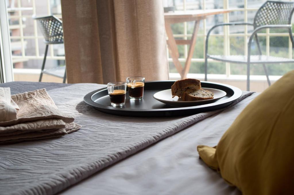 Great View Luxury Living في سلانيك: طاولة مع صحن من الطعام وكأسين من العصير