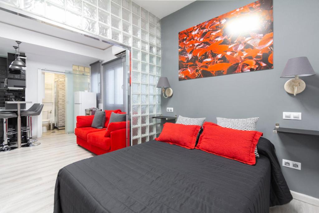 a bedroom with a bed and a red chair at Argüelles Apartment in Madrid