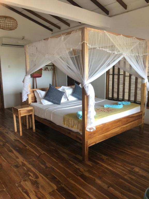a bedroom with a bed with a canopy at C Beyond Nilaveli in Nilaveli