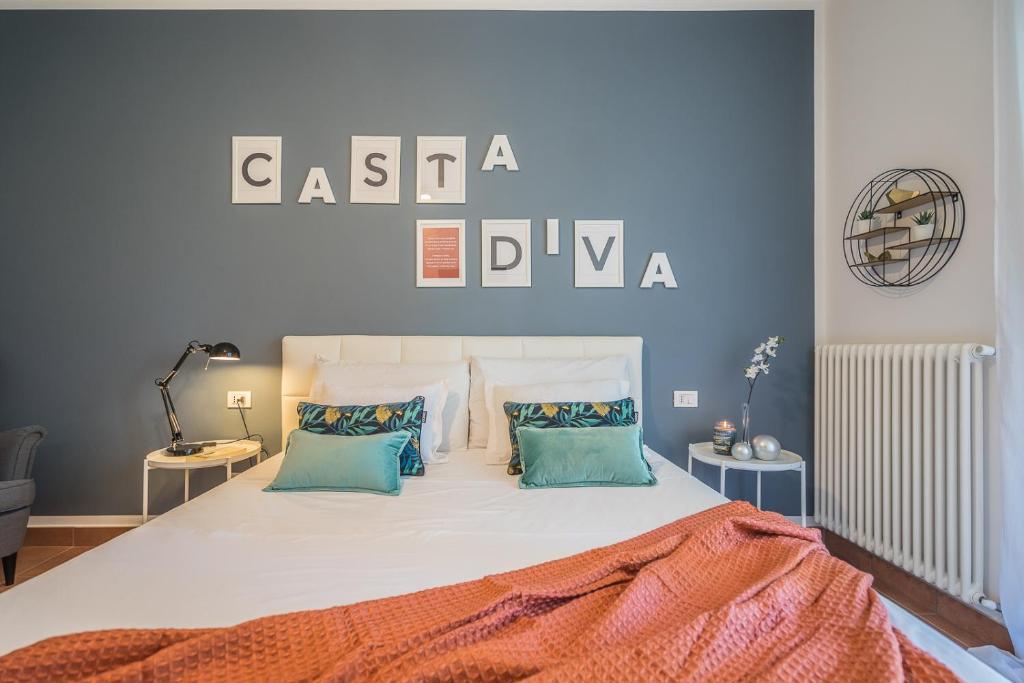 a bedroom with a large bed with blue walls at Callas Family Apartment in Sirmione