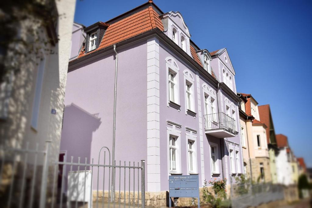 ein weißes Gebäude mit rotem Dach auf einer Straße in der Unterkunft Domfreiheit in Naumburg